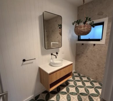 Bathroom with floating oak vanity and patterned tile floor